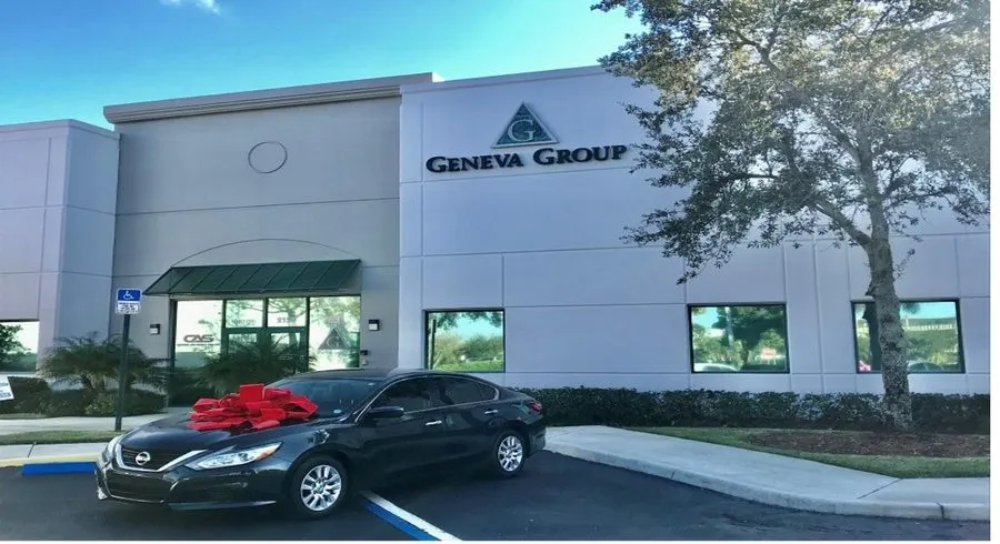 Donated car with a red bow outside Geneva Group headquarters