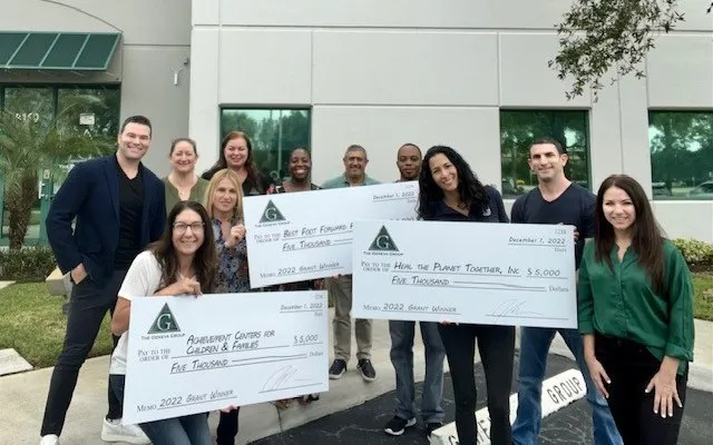 Geneva team presenting the 2022 Geneva Foundation grant checks outside the firm's Deerfield Beach headquarters